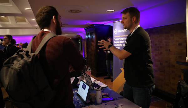 A photo of Sven discussing Mautic at State of Open Con with a delegate.